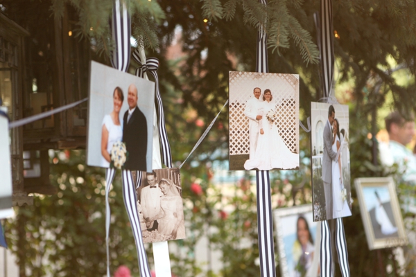 Photos strung on tree branches with string.
