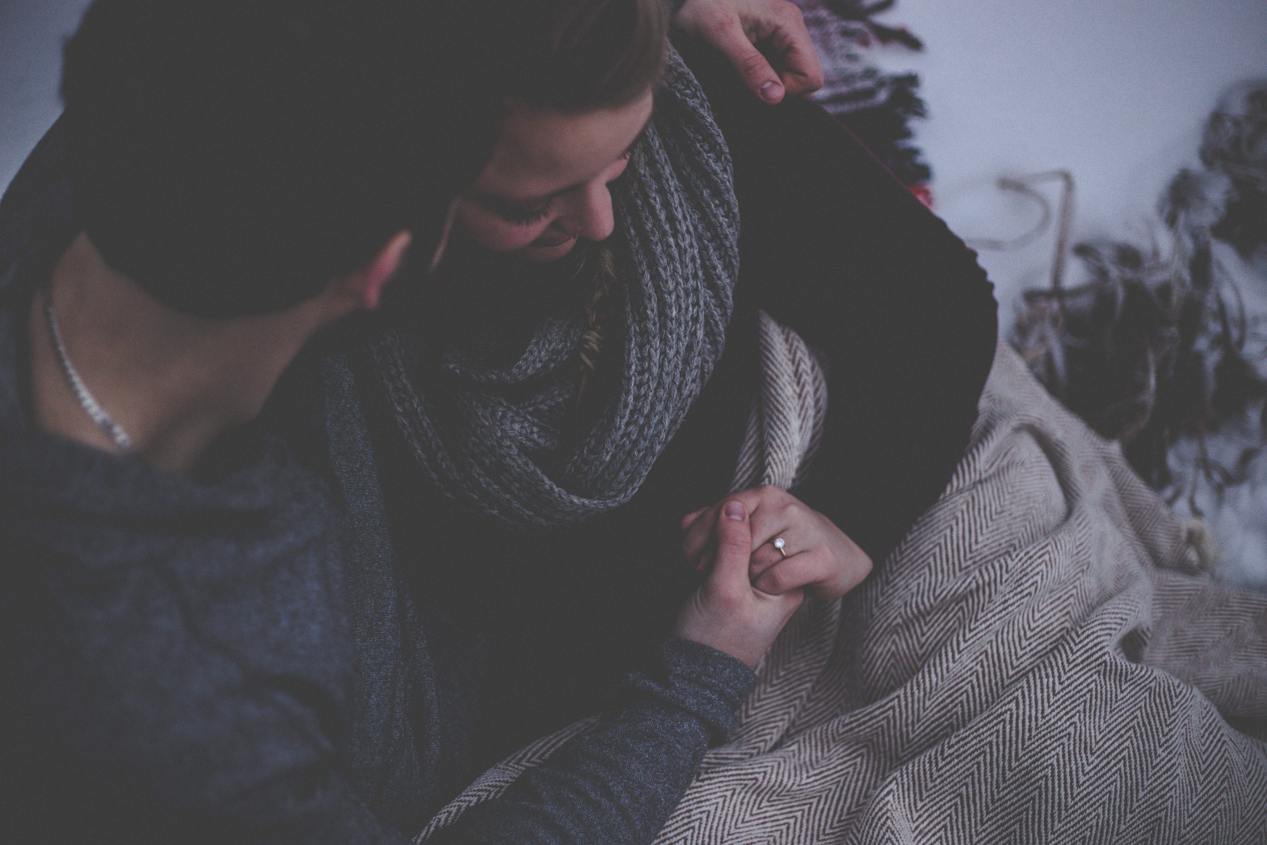 Couple cuddling on a couch.