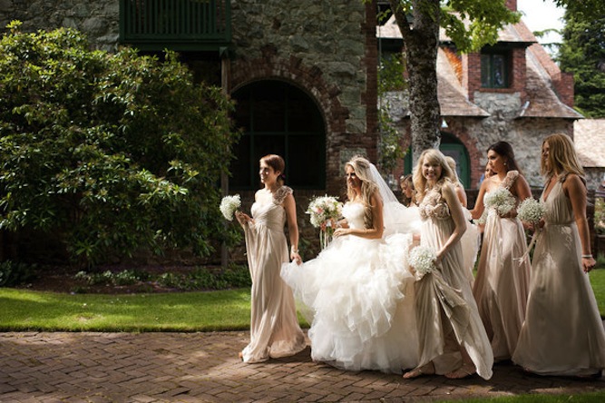 Bridesmaids holding bride's wedding dress.