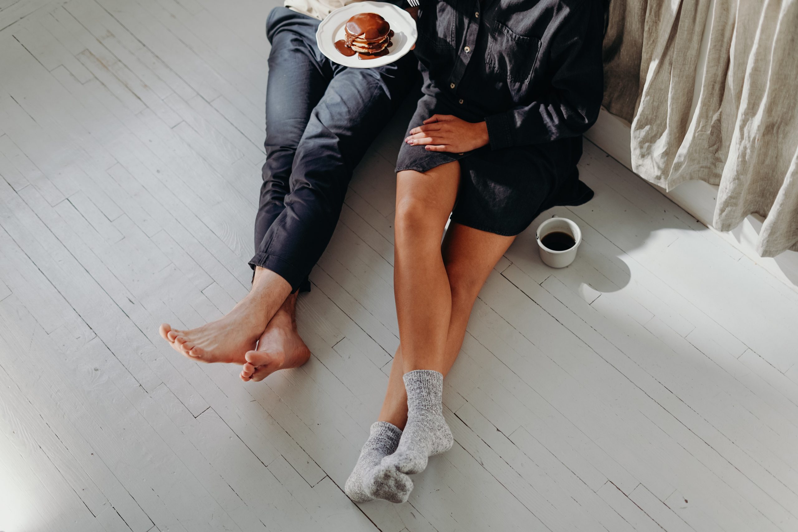 Couple sitting on floor enjoying breakfast.