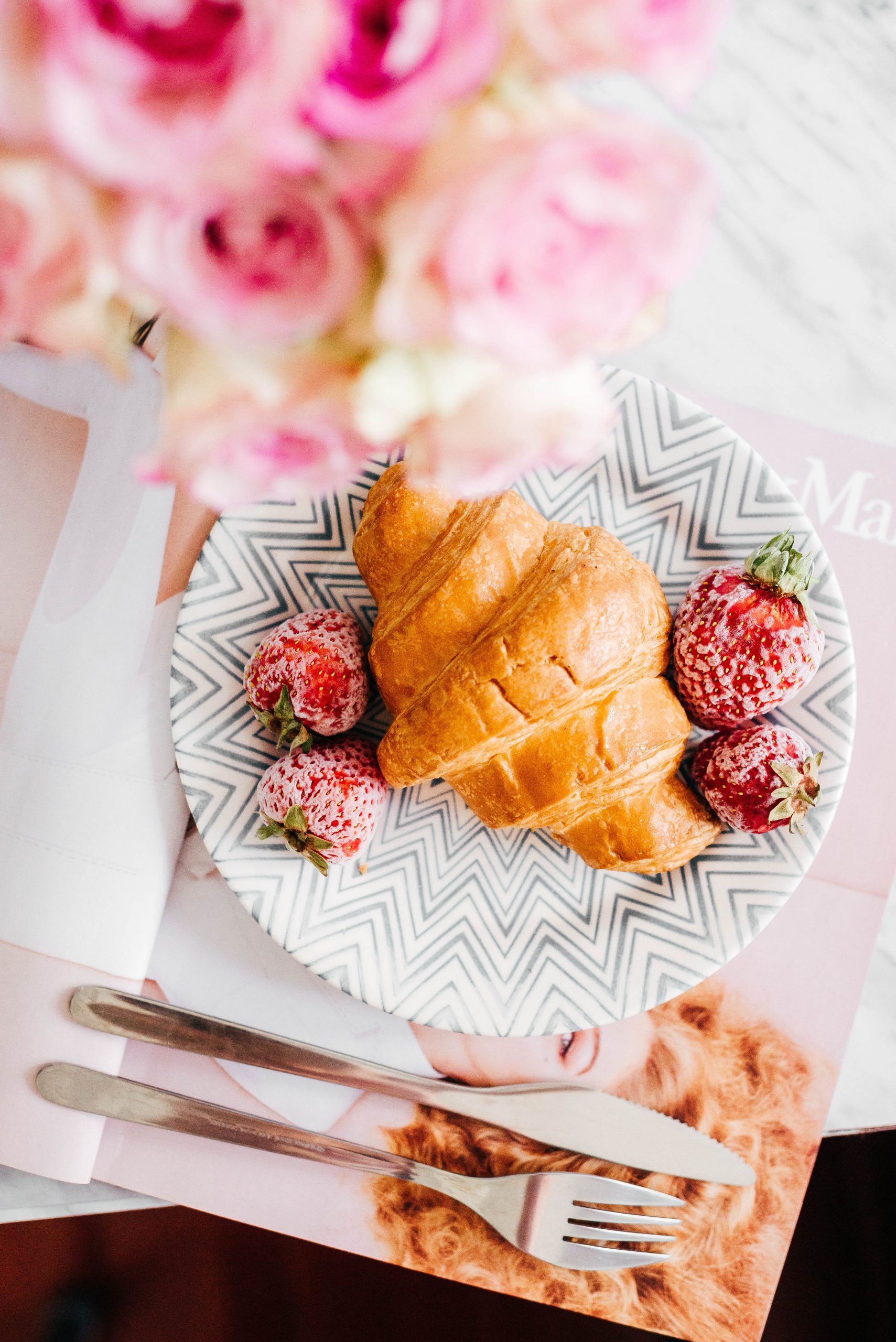 Plate with croissant and berries on top.