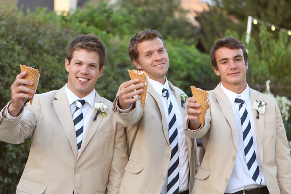 Three men wearing suits and ties holding up ice cream waffle cones.