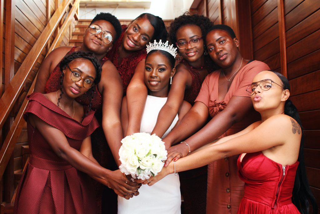 Bridesmaids sitting on a staircase around the bride.