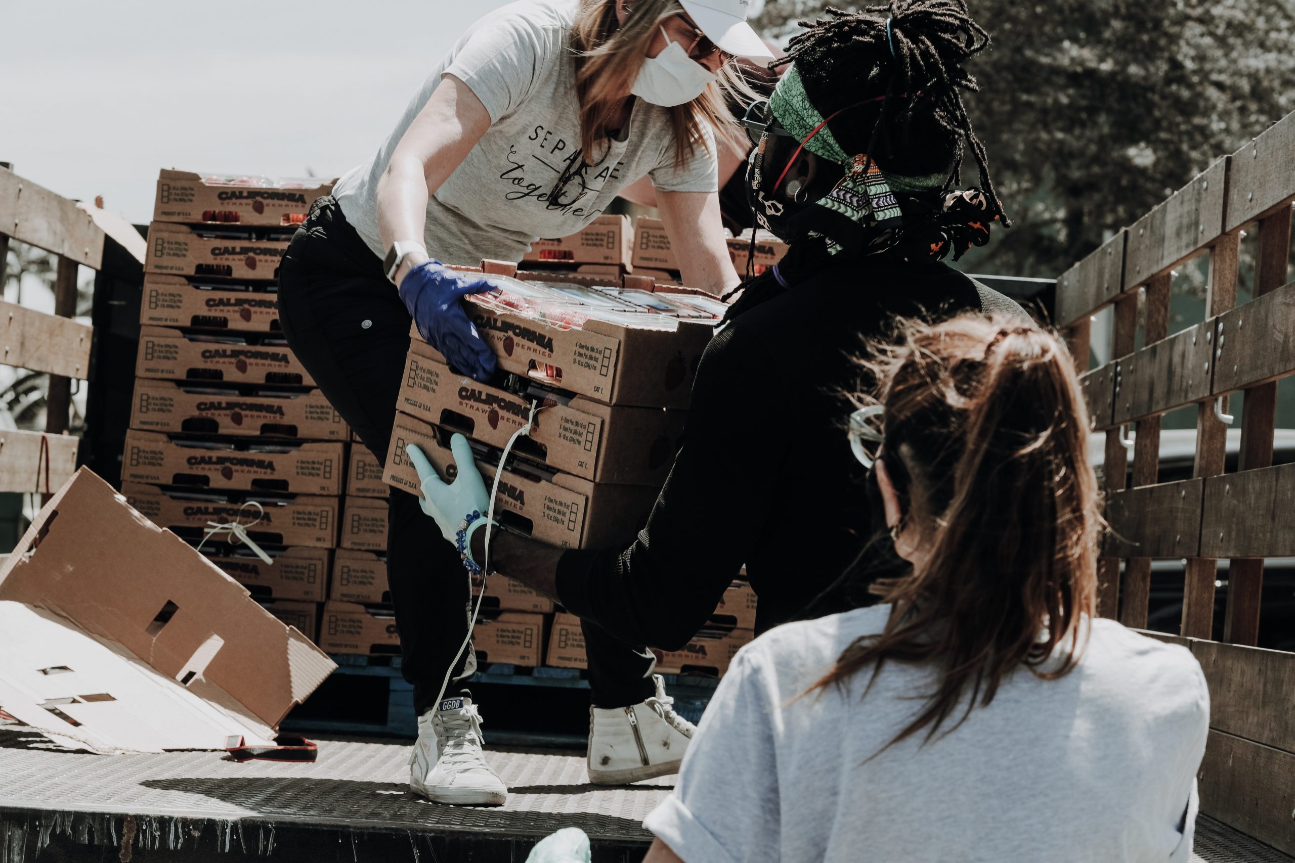 people helping unload boxes from truck for charity