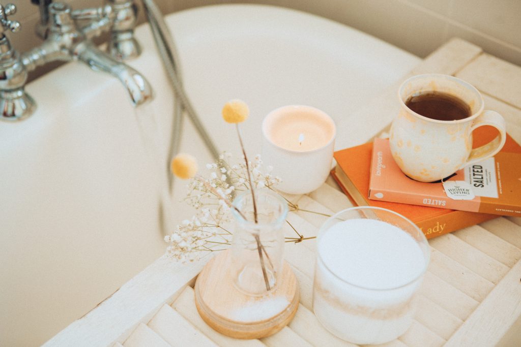 Bathtub with candles, flowers, tea, and reading materials. -- DIY facial