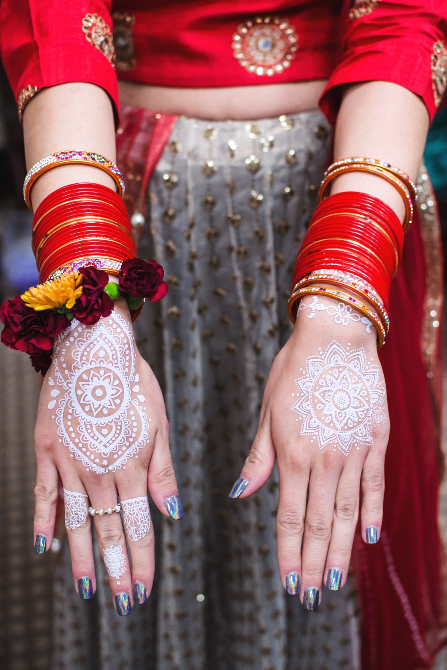 Bride holding our her hands with henna. 