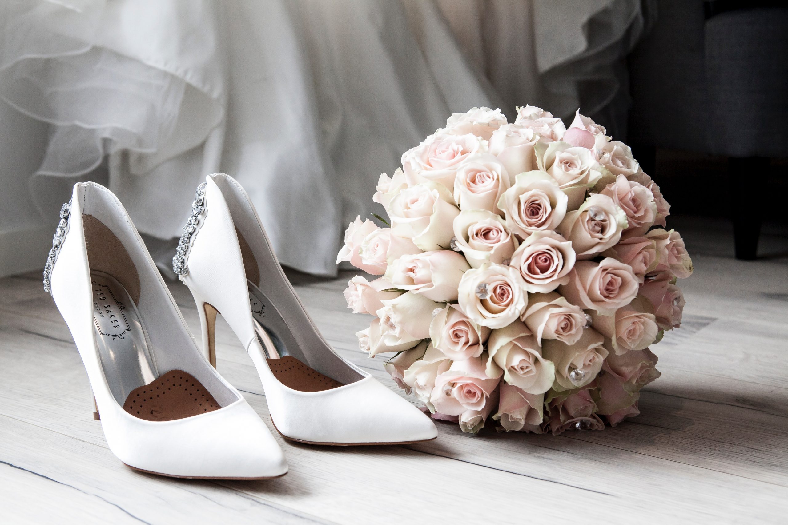 Shoes and flower bouquet on floor.