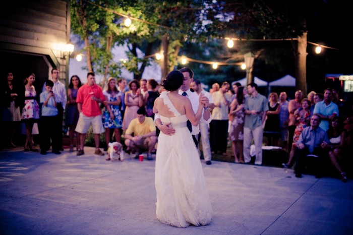 Newlyweds dancing while guests stand at the edges of the dance floor.