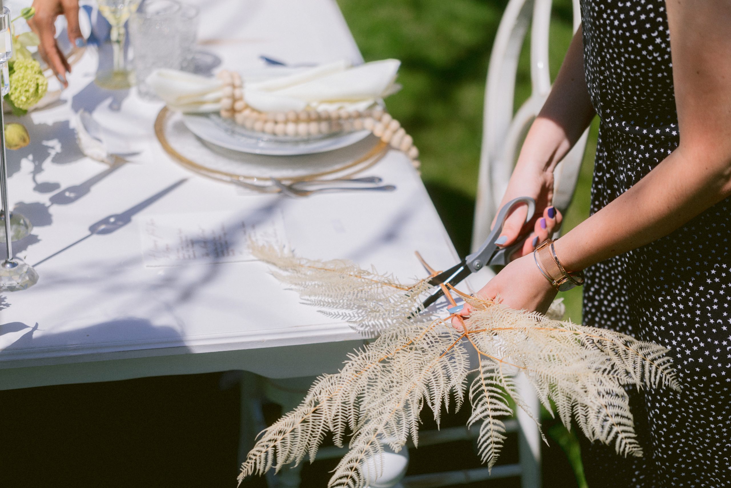 A person cutting a decorative palm for a table setting