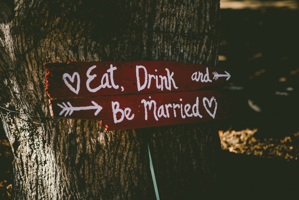 a sign on a tree reading "eat, drink, and be married"