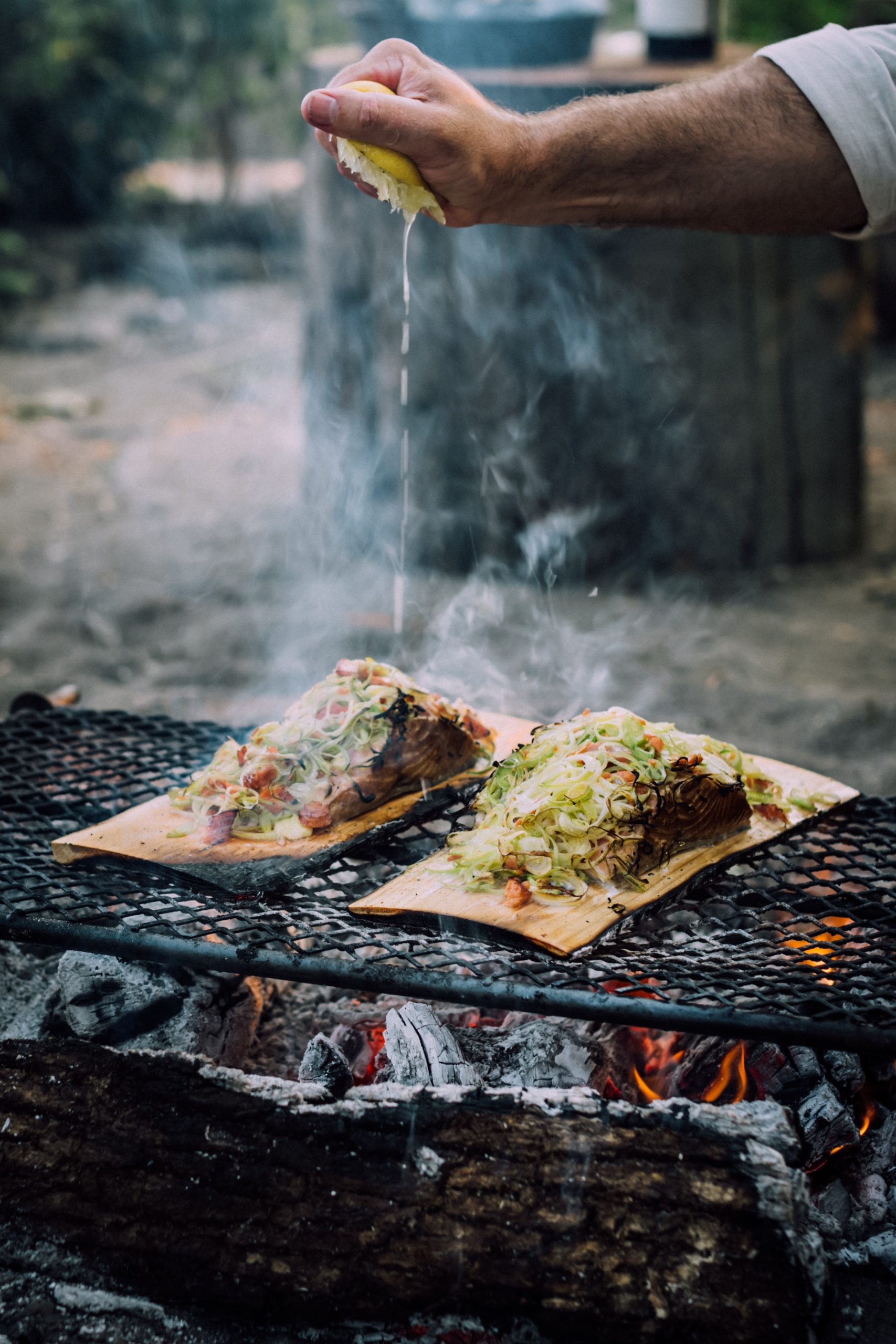 Cedar plank salmon and vegetables cooked over an open fire.