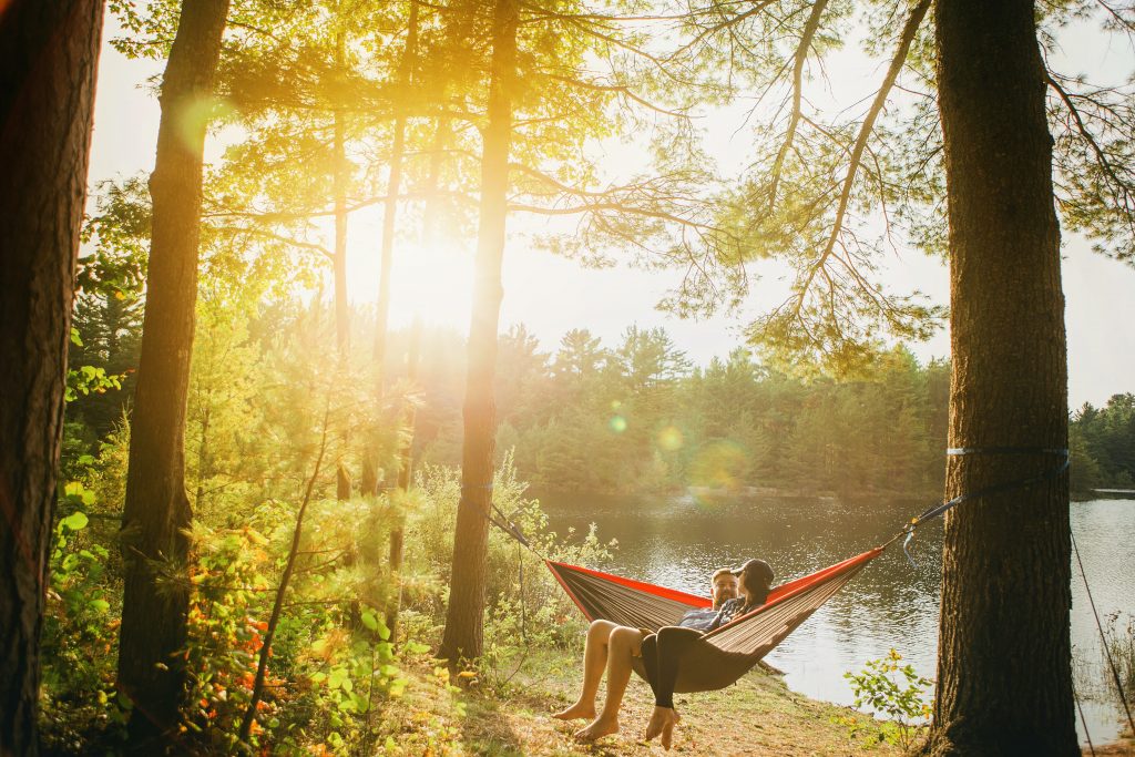 A couple in a hammock overlooking a lake