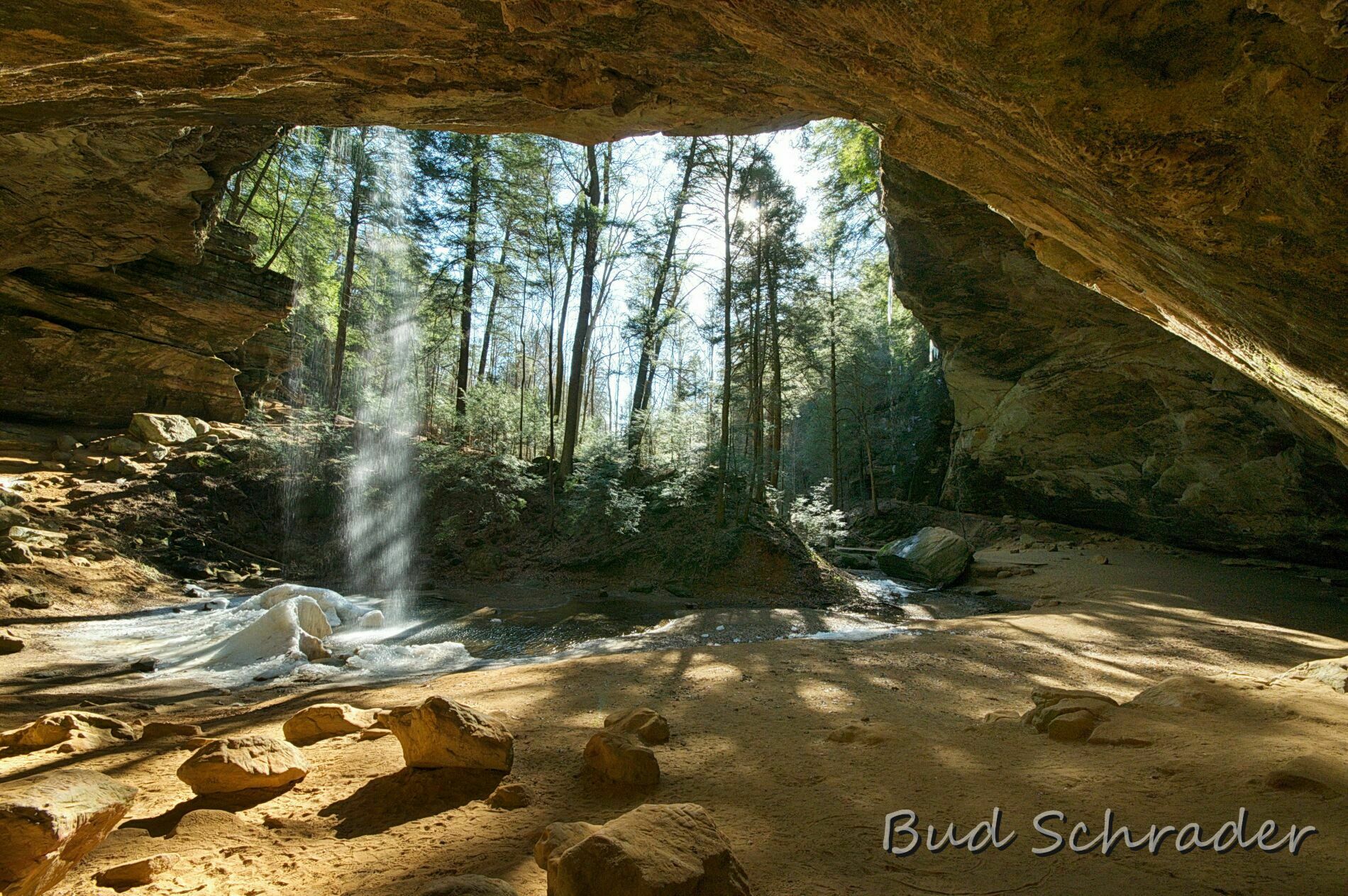 photo from inside of cave looking at curve of cave walls and sunlight streaming in 